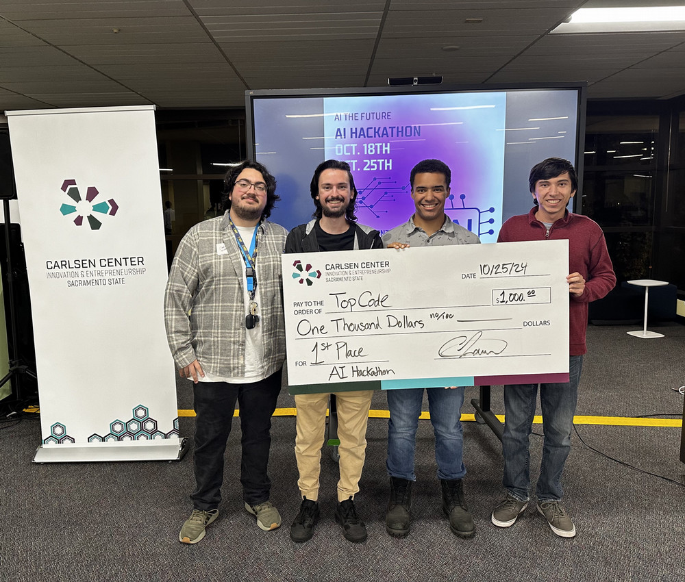 Team TopCode holding the first-place check